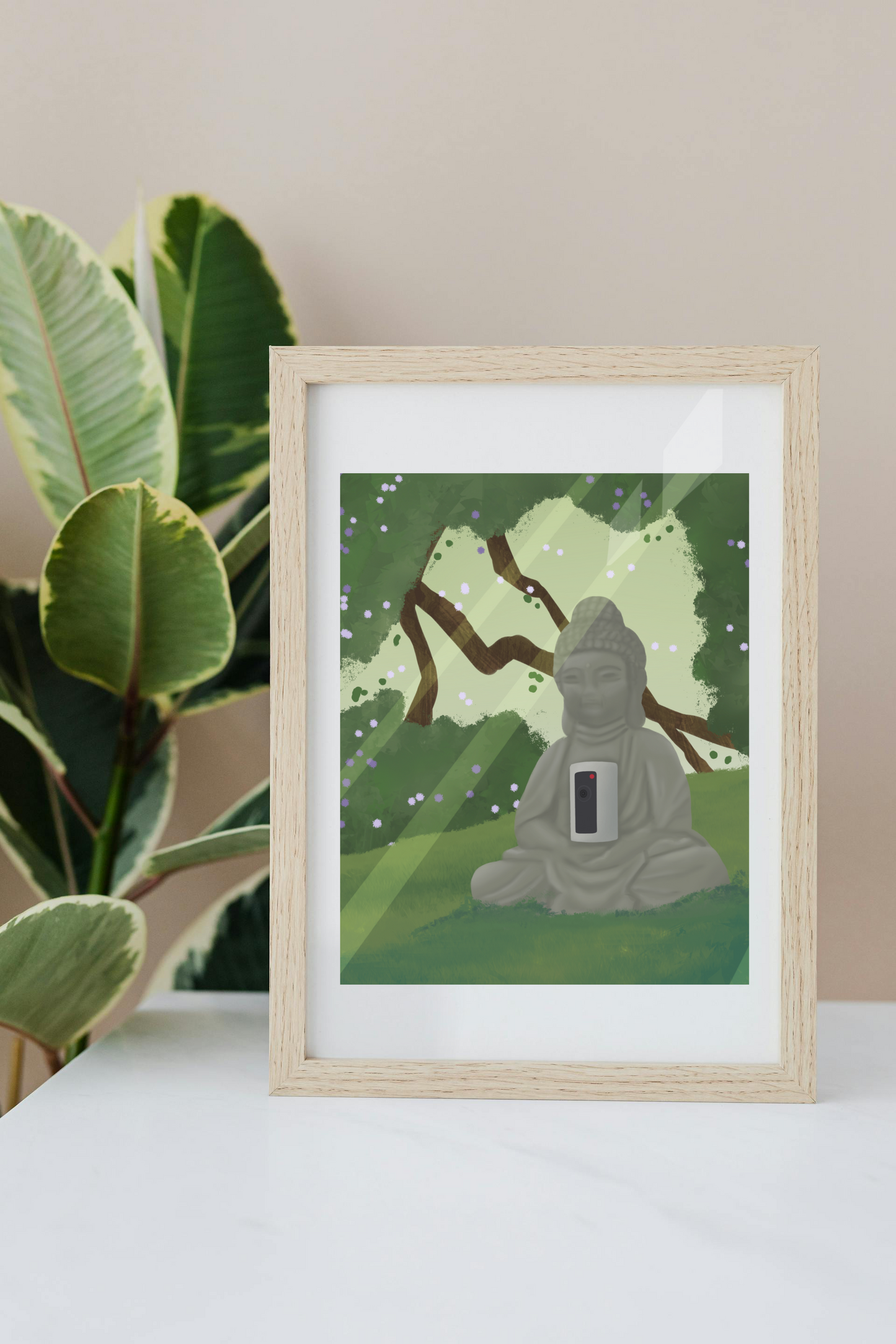 Framed art print on a white surface with a plant in the background of an illustration of a buddha statue with a security camera embedded into it, surrounded by trees, grass, and sunlight.